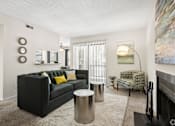 Thumbnail 15 of 17 - A black couch with yellow pillows is in the center of a living room.