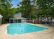 Thumbnail 17 of 17 - A small pool surrounded by trees and a building.