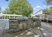 Thumbnail 4 of 17 - A stone grill is in the middle of a patio.