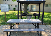 Thumbnail 31 of 31 - A gazebo with a canopy is surrounded by a brick patio and a sign that reads "Community Girls.".
