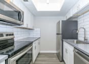 Thumbnail 10 of 19 - a kitchen with stainless steel appliances and white cabinets at Tides on Southern, Mesa, AZ 85204