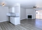 Thumbnail 13 of 17 - an empty living room with a kitchen and a fireplace at Tides at Mesa, Mesa, AZ, 85204