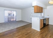 Thumbnail 16 of 19 - an empty kitchen and living room with wood flooring and a window at Tides on Southern, Mesa, AZ 85204