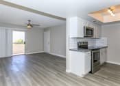 Thumbnail 9 of 19 - an empty kitchen and living room with a ceiling fan at Tides on Southern, Mesa
