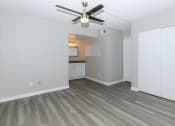 Thumbnail 11 of 19 - an empty living room with a ceiling fan and a kitchen at Tides on Southern, Arizona