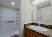 Thumbnail 8 of 16 - A white bathroom with a sink and a mirror.