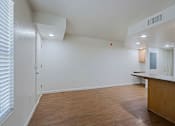 Thumbnail 5 of 16 - A room with a wooden floor and a white ceiling with a vent.