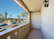 Thumbnail 16 of 21 - a balcony with a view of a parking lot