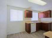 Thumbnail 11 of 21 - a kitchen with brown cabinets and a white dishwasher