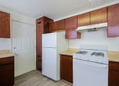 Thumbnail 12 of 21 - a kitchen with white appliances and wooden cabinets