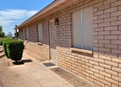 Thumbnail 1 of 3 - a brick building with two windows and a white door