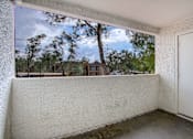 Thumbnail 12 of 26 - A room with a view of a tree-filled landscape through a window.