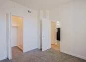 Thumbnail 6 of 21 - a bedroom with white walls and doors and a carpeted floor
