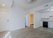 Thumbnail 4 of 21 - the living room and kitchen of an apartment with white walls and wood flooring