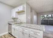 Thumbnail 3 of 26 - A kitchen with white cabinets and granite countertops.