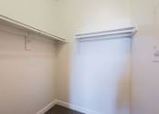 Thumbnail 8 of 21 - a walk in closet with a white wall and a sliding closet door