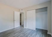 Thumbnail 10 of 15 - A room with white doors and grey flooring.