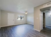 Thumbnail 3 of 15 - A room with a white door, a window, and a wooden floor.