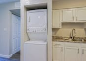 Thumbnail 6 of 15 - A white dishwasher is in a kitchen with white cabinets.