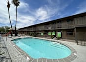 Thumbnail 16 of 18 - A swimming pool in a resort with a clear blue sky.