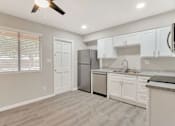 Thumbnail 1 of 9 - an empty kitchen with white cabinets and a stainless steel refrigerator
