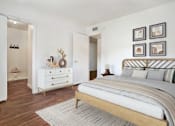 Thumbnail 8 of 8 - A bedroom with a large bed and a dresser with a mirror at Foothills Court Apartments, Phoenix, AZ 85029