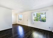 Thumbnail 9 of 25 - A room with a white door and a window with a view of trees outside.