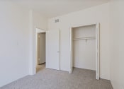 Thumbnail 14 of 21 - a bedroom with white walls and a closet with two doors
