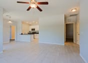 Thumbnail 2 of 23 - an empty living room with a ceiling fan and a kitchen