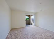 Thumbnail 6 of 17 - A room with a carpeted floor and a doorway leading to another room.