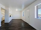 Thumbnail 26 of 30 - A large empty room with wooden floors and white walls.