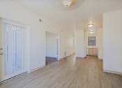 Thumbnail 10 of 21 - a spacious living room with white walls and wood flooring