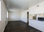 Thumbnail 25 of 30 - A room with a white ceiling and wooden floors.