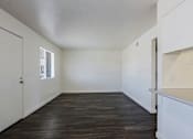 Thumbnail 24 of 30 - A room with wooden floors and white walls.