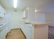 Thumbnail 2 of 17 - A kitchen with white appliances and cabinets.