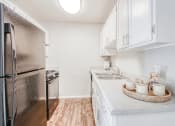 Thumbnail 4 of 27 - a renovated kitchen with stainless steel appliances and white cabinets