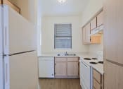 Thumbnail 11 of 21 - an empty kitchen with white appliances and wooden cabinets