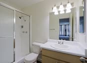 Thumbnail 12 of 25 - A white bathroom with a toilet, sink, and shower.