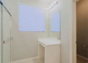 Thumbnail 10 of 23 - a bathroom with a sink and a shower and a window