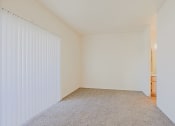 Thumbnail 15 of 21 - a spacious living room with white walls and a window with white blinds