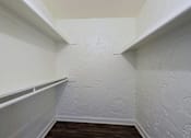 Thumbnail 13 of 25 - A white wall with a wooden floor and a white shelf.