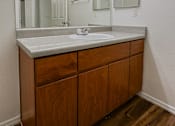 Thumbnail 13 of 22 - A bathroom vanity with a sink and mirror.