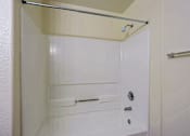 Thumbnail 12 of 22 - A white bathroom with a shower door open.