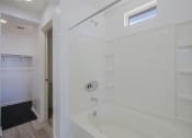 Thumbnail 5 of 14 - a white bathroom with a tub and a shower