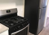 Thumbnail 12 of 13 - a kitchen with a stove and a refrigerator