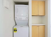 Thumbnail 4 of 25 - A white dishwasher is in a kitchen next to a wooden cabinet.