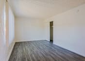 Thumbnail 5 of 25 - A room with wooden flooring and white walls.