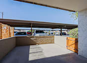 Thumbnail 7 of 25 - A parking lot is visible through a gap in a fence.