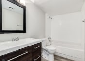 Thumbnail 5 of 10 - a bathroom with a toilet and a sink and a mirror