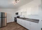 Thumbnail 1 of 14 - a kitchen with stainless steel appliances and white cabinets